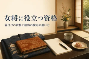 女将に役立つ着付けの資格や接客の検定を紹介する記事のアイキャッチ。和室の座卓に着物とノート