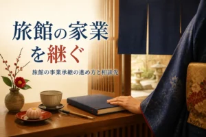 旅館の事業承継の進め方を紹介する記事のアイキャッチ。旅館の帳場の机と帳面に添えた手元